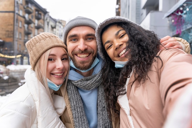 Amigos sonrientes de tiro medio tomando selfie