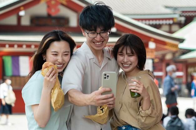 Amigos sonrientes de tiro medio tomando selfie