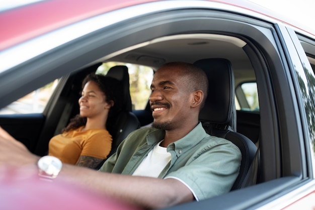 Amigos sonrientes de tiro medio viajando en coche