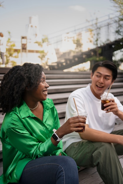 Foto gratuita amigos sonrientes con vista lateral de café helado