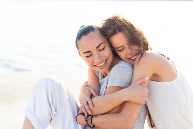 Foto gratuita amigos sonrientes de la vista lateral que abrazan