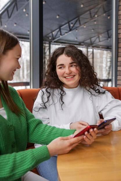 Amigos sonrientes de vista lateral con teléfono inteligente