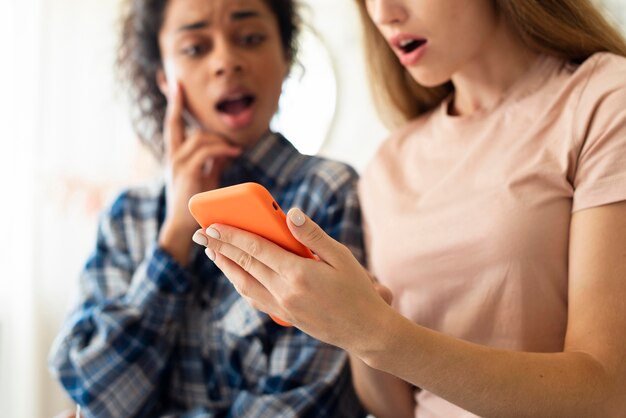 Amigos sorprendidos por lo que ven en el teléfono inteligente