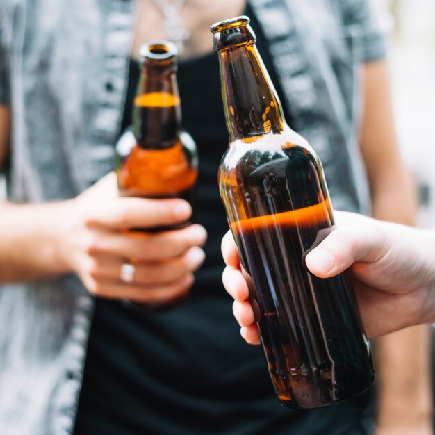 Amigos sosteniendo una botella de cerveza