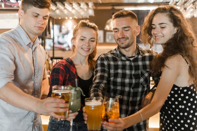 Amigos sosteniendo copas de bebidas celebrando juntos