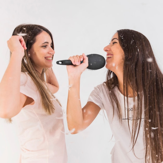 Amigos sosteniendo peine cantando canción con sus amigos bailando