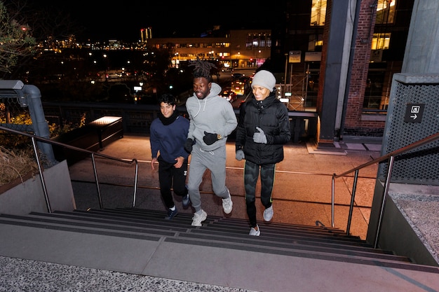 Amigos subiendo las escaleras por la noche en la ciudad