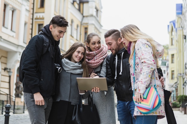 Amigos con tableta en la calle de la ciudad