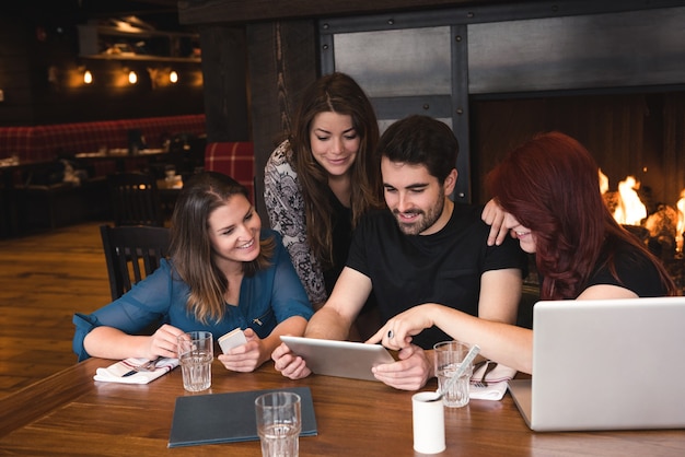 Amigos con tableta digital en la barra