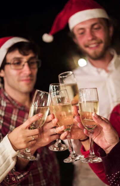 Amigos tintinean copas de champán tostado de Navidad