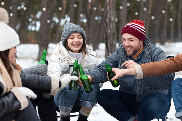 Amigos tintineando botellas de cerveza en la naturaleza