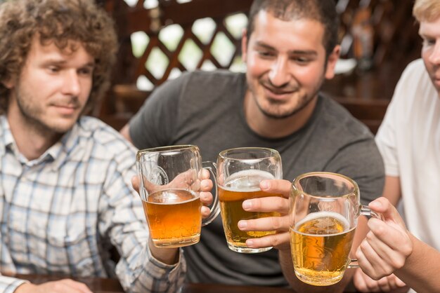 Amigos tintineando vasos en la barra