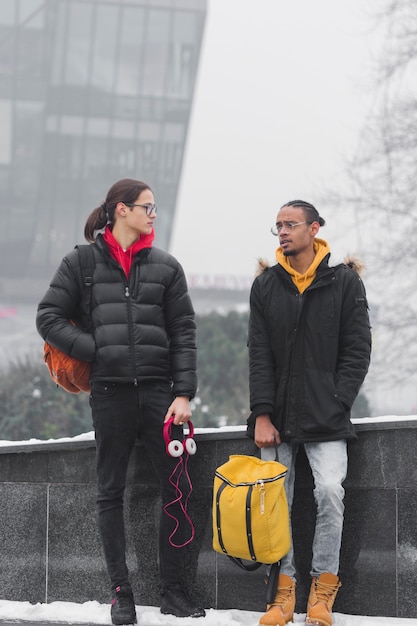 Amigos de tiro completo con auriculares rosas y mochila