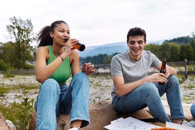 Amigos de tiro completo con bebidas al aire libre.