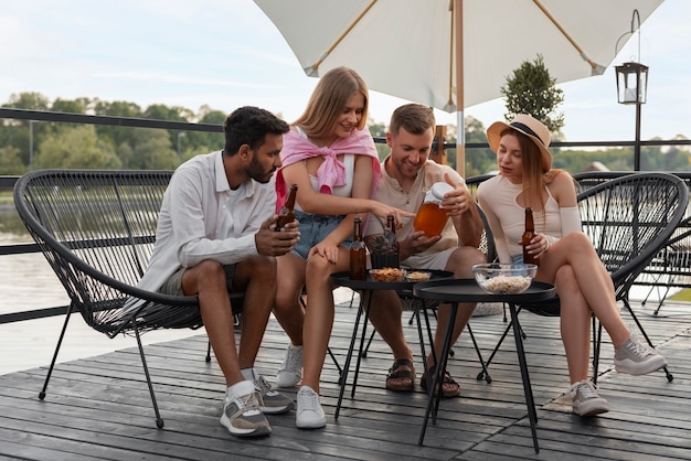 Amigos de tiro completo con deliciosa kombucha al aire libre.