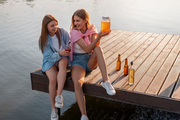 Amigos de tiro completo con deliciosa kombucha al aire libre.