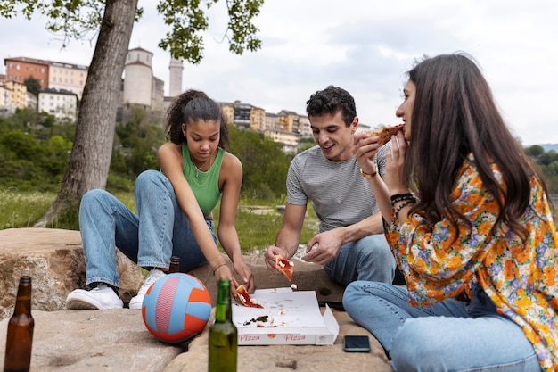 Amigos de tiro completo con deliciosa pizza.