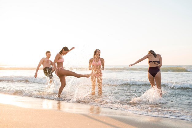 Amigos de tiro completo divirtiéndose en la playa