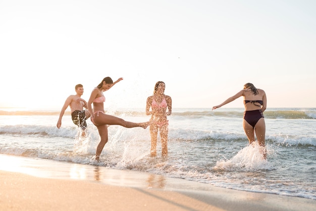 Amigos de tiro completo divirtiéndose en la playa