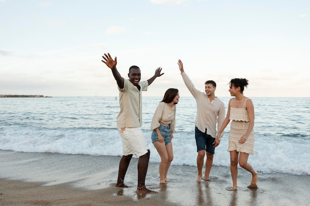 Amigos de tiro completo divirtiéndose en la playa