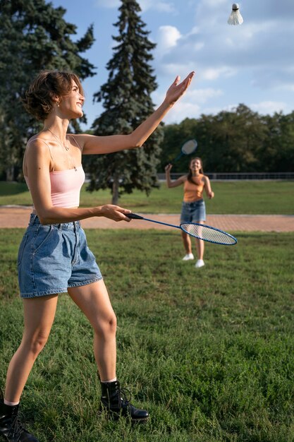 Amigos de tiro completo jugando al bádminton.