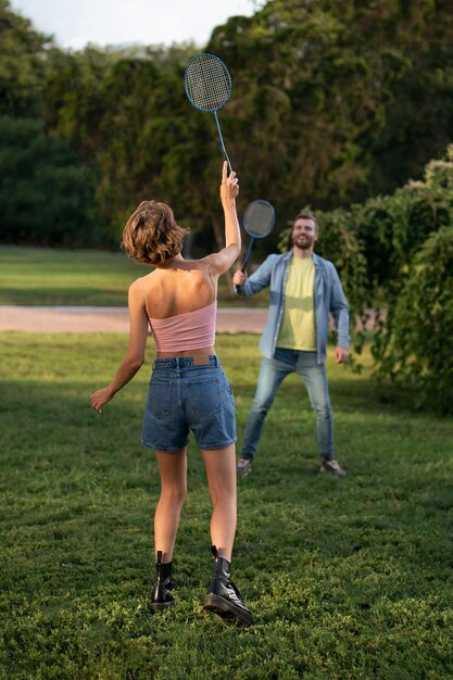 Amigos de tiro completo jugando al bádminton.