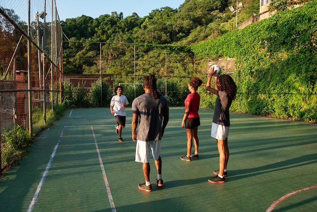 Foto gratuita amigos de tiro completo jugando al fútbol