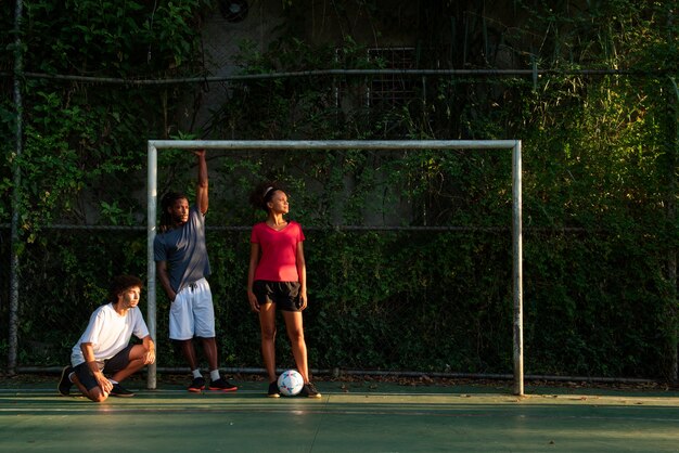 Amigos de tiro completo jugando al fútbol