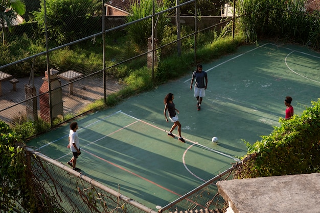 Amigos de tiro completo jugando al fútbol