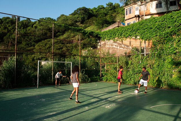 Amigos de tiro completo jugando al fútbol