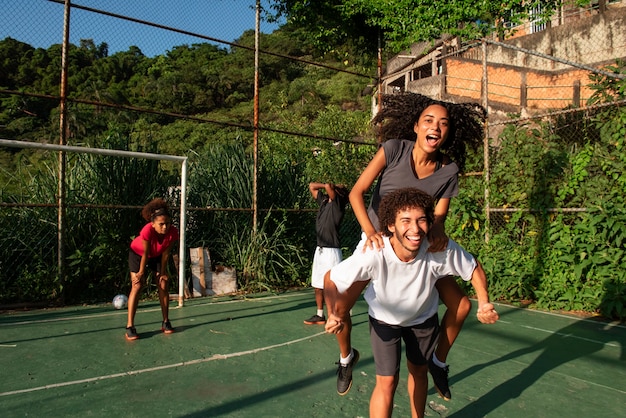 Foto gratuita amigos de tiro completo jugando al fútbol