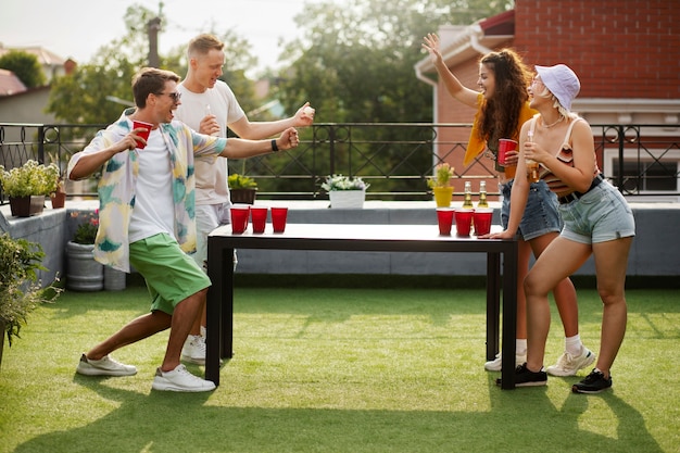 Amigos de tiro completo jugando beer pong