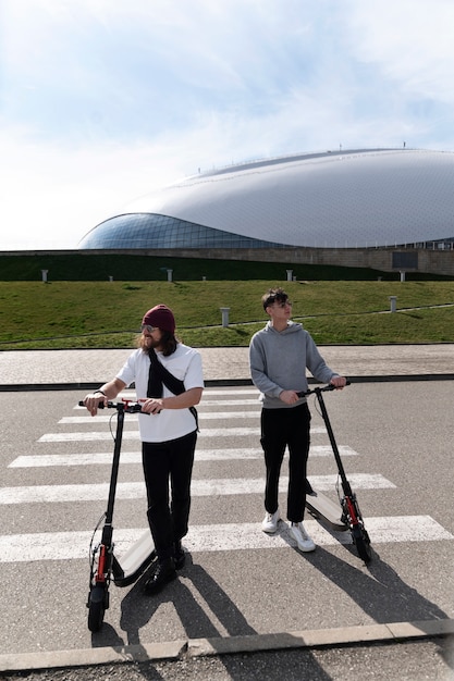 Amigos de tiro completo con scooters eléctricos.