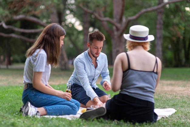 Foto gratuita amigos de tiro completo sentados al aire libre