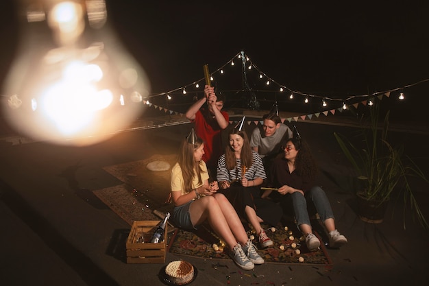 Amigos de tiro completo sentados al aire libre