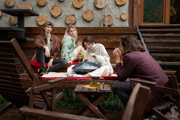 Amigos de tiro completo sentados al aire libre