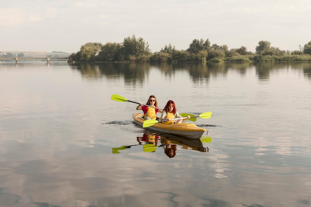 Amigos de tiro largo remando en kayak