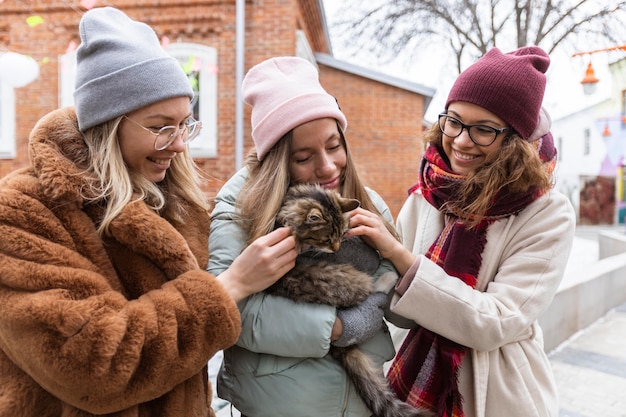 Foto gratuita amigos de tiro medio acariciando gato