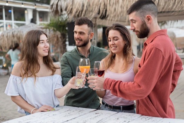 Foto gratuita amigos de tiro medio brindando al aire libre