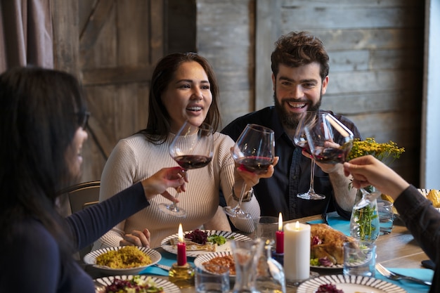 Foto gratuita amigos de tiro medio cenando juntos