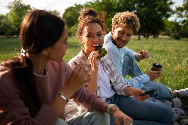 Foto gratuita amigos de tiro medio comiendo bocadillos de algas