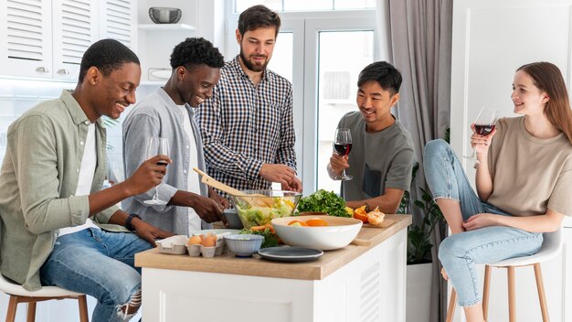 Amigos de tiro medio comiendo juntos