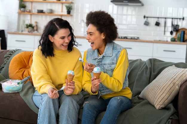 Amigos de tiro medio comiendo un sabroso helado.