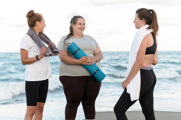 Amigos de tiro medio con esterilla de yoga