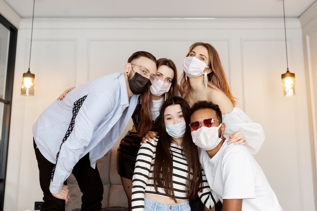 Amigos de tiro medio en la fiesta con máscaras faciales