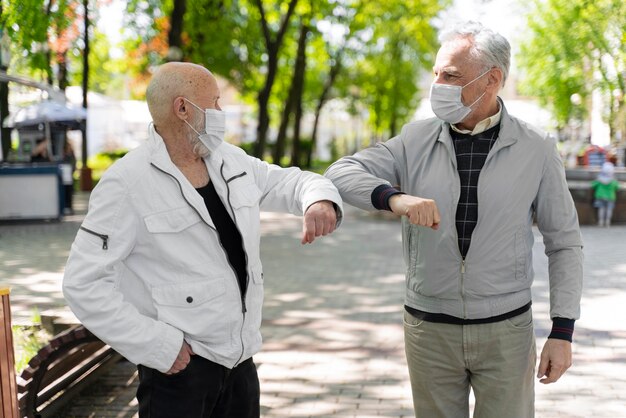 Amigos de tiro medio golpeando el codo