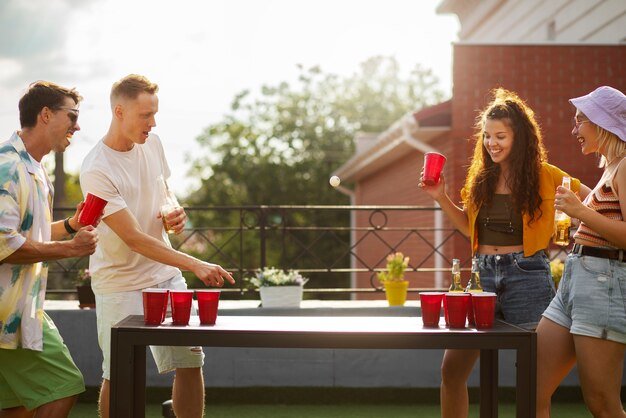 Amigos de tiro medio jugando al beer pong