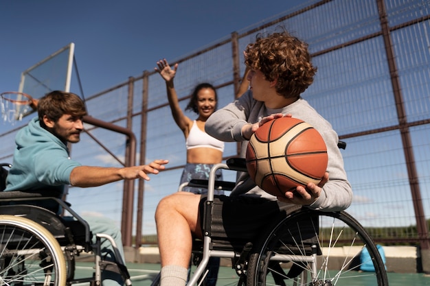 Amigos de tiro medio jugando baloncesto juntos