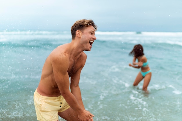 Foto gratuita amigos de tiro medio jugando en el mar