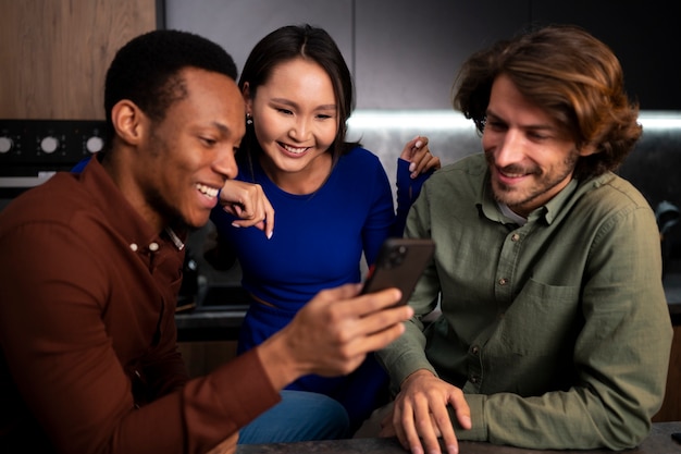 Amigos de tiro medio leyendo mensajes de teléfono celular